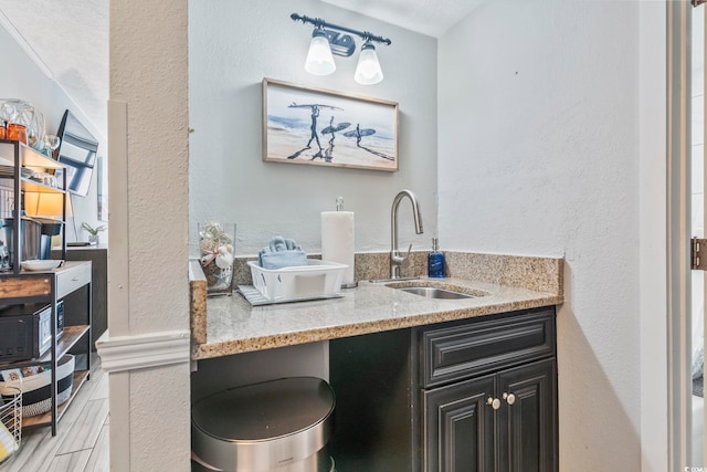 bathroom featuring a textured wall, wood finished floors, and vanity