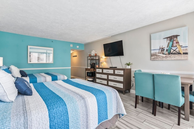 bedroom with a textured ceiling and wood tiled floors