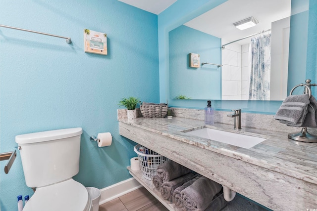 full bathroom featuring toilet, a shower with curtain, baseboards, and vanity