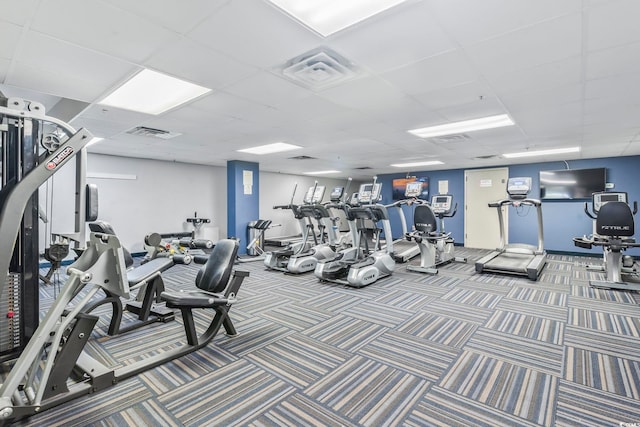 workout area with a paneled ceiling and carpet