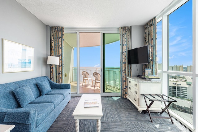 living area featuring floor to ceiling windows, a textured ceiling, and dark colored carpet