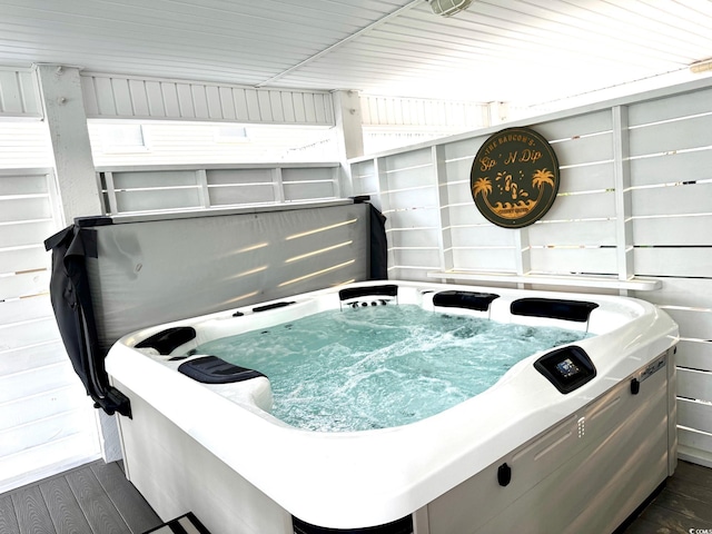 miscellaneous room with a hot tub and dark wood-type flooring