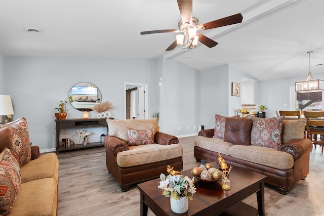living area with ceiling fan, visible vents, baseboards, light wood finished floors, and vaulted ceiling with beams