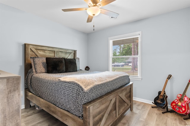 bedroom featuring baseboards, visible vents, ceiling fan, and light wood-type flooring
