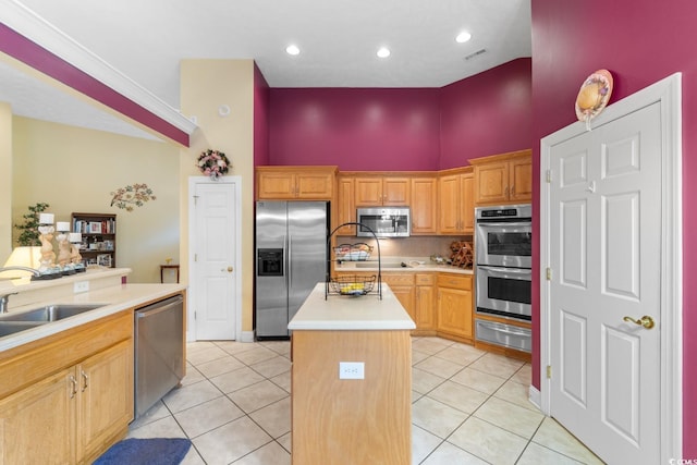 kitchen with a center island with sink, a sink, light countertops, a warming drawer, and stainless steel appliances