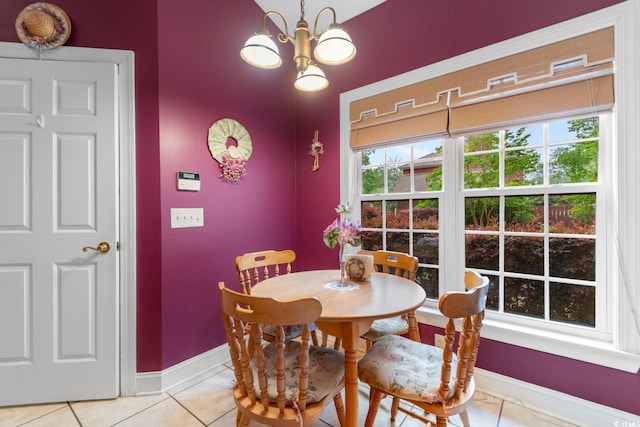 dining space featuring baseboards, light tile patterned floors, and an inviting chandelier