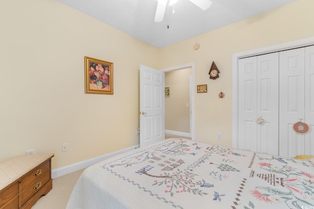 bedroom featuring baseboards, light colored carpet, ceiling fan, and a closet