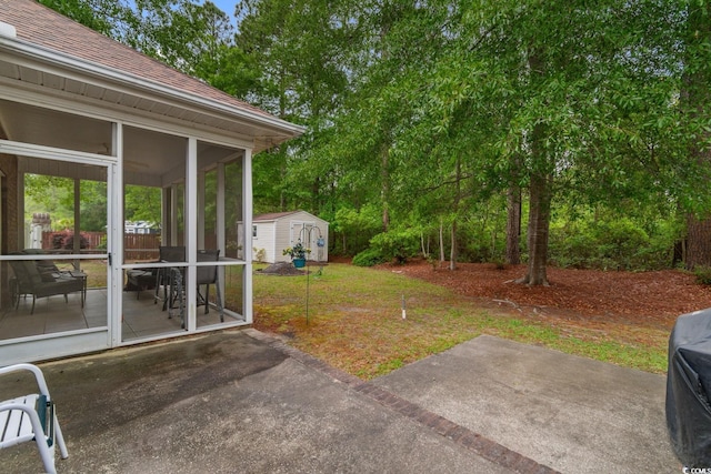 view of yard featuring a storage shed, an outbuilding, a patio area, and a sunroom