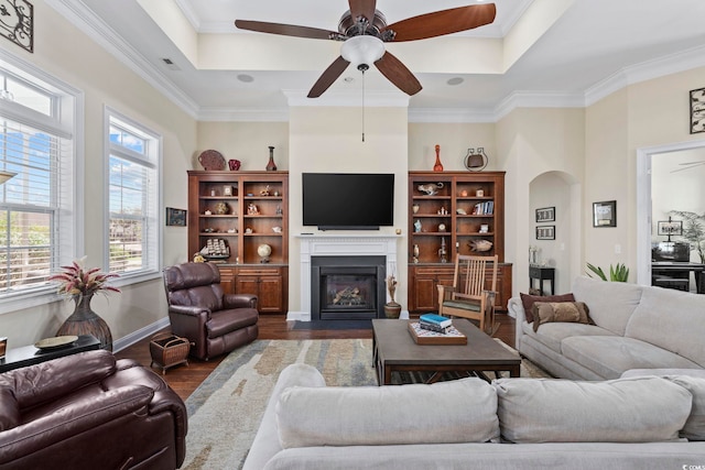 200 Stonefly Ct, Murrells Inlet, SC 29576 - living room with a ceiling fan, a fireplace with flush hearth, arched walkways, crown molding, and dark wood-type flooring