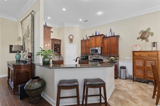 200 Stonefly Ct, Murrells Inlet, SC 29576 - kitchen with crown molding, tasteful backsplash, stainless steel appliances, a peninsula, and a kitchen bar