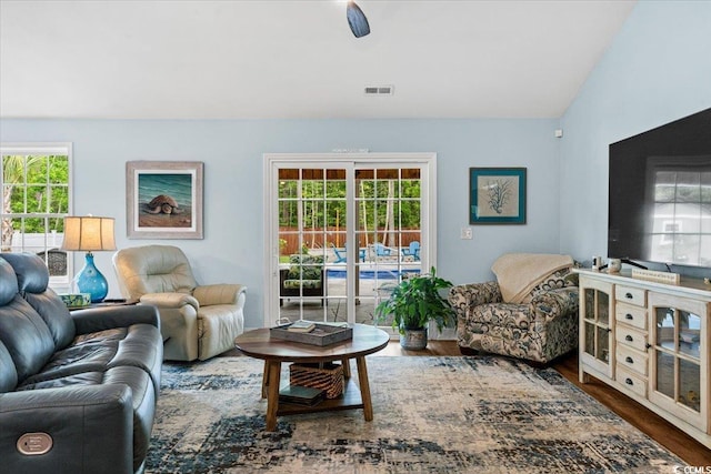 living room with lofted ceiling, wood finished floors, and visible vents