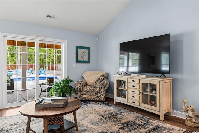living room with visible vents, vaulted ceiling, wood finished floors, and baseboards