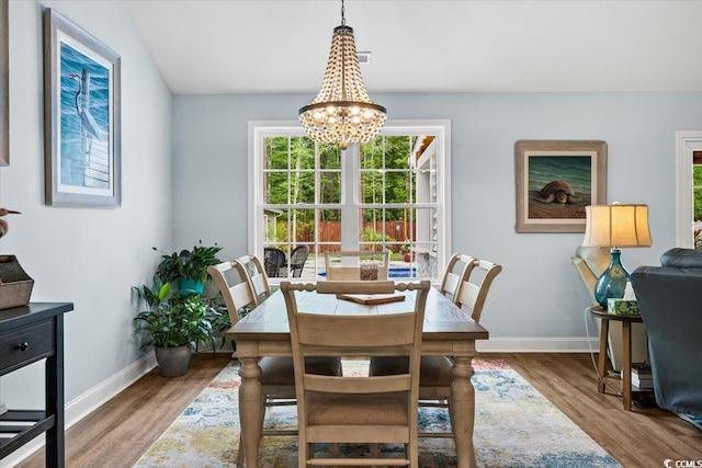 dining area with an inviting chandelier, wood finished floors, and baseboards