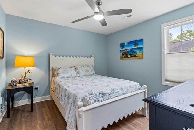 bedroom with a ceiling fan, visible vents, wood finished floors, and baseboards