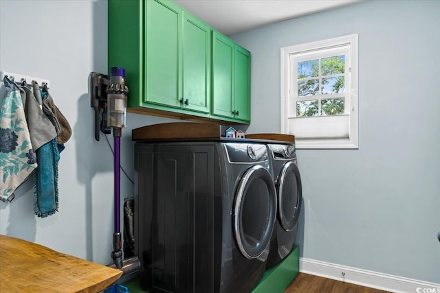 clothes washing area with washer and clothes dryer, cabinet space, dark wood finished floors, and baseboards