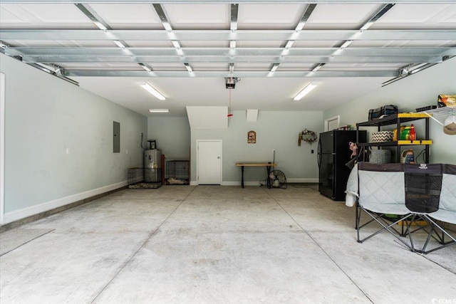 garage featuring electric panel, water heater, and freestanding refrigerator