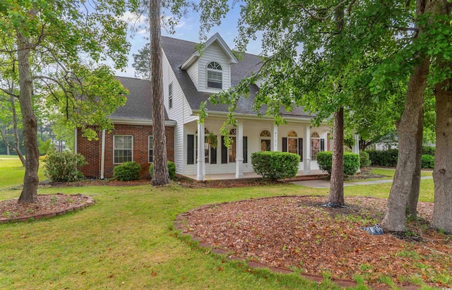 4721 National Dr, Myrtle Beach, SC 29579 - cape cod-style house featuring a porch, a shingled roof, and a front lawn