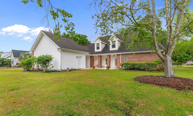 4721 National Dr, Myrtle Beach, SC 29579 - new england style home featuring a front yard, brick siding, and fence