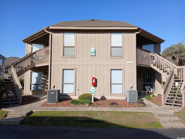 back of property featuring central AC unit and stairway