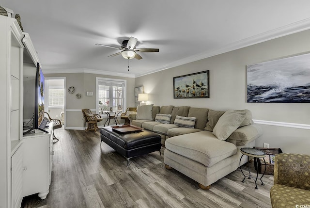 living room featuring ornamental molding, wood finished floors, baseboards, and ceiling fan