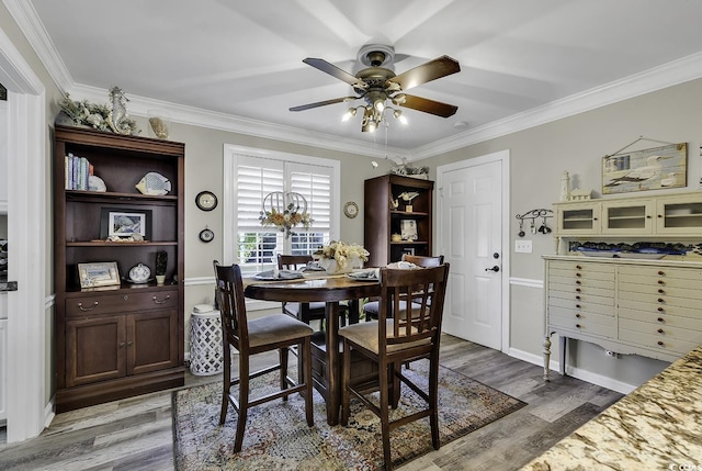 dining room featuring ornamental molding, a ceiling fan, and light wood-style floors