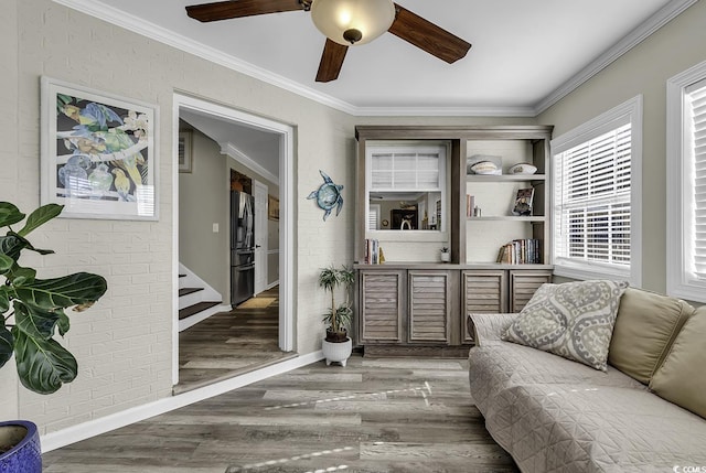sitting room featuring crown molding, stairway, wood finished floors, and ceiling fan
