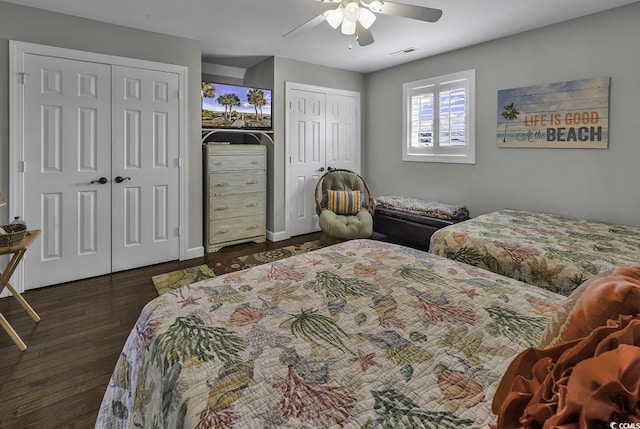 bedroom with a ceiling fan, baseboards, visible vents, two closets, and wood finished floors