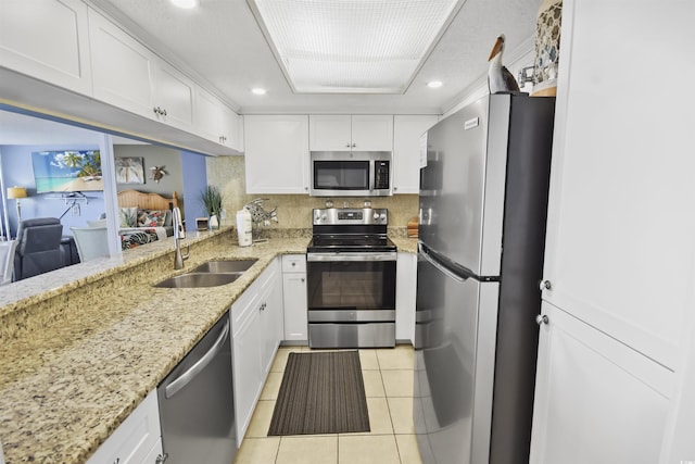 9820 Queensway Blvd Unit 704, Myrtle Beach, SC 29572 - kitchen with stainless steel appliances, light tile patterned flooring, white cabinets, light stone counters, and backsplash