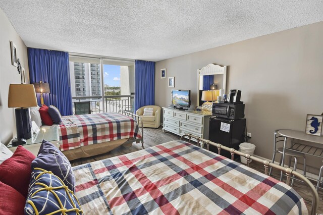 9820 Queensway Blvd Unit 704, Myrtle Beach, SC 29572 - bedroom featuring access to exterior, a textured ceiling, and wood finished floors