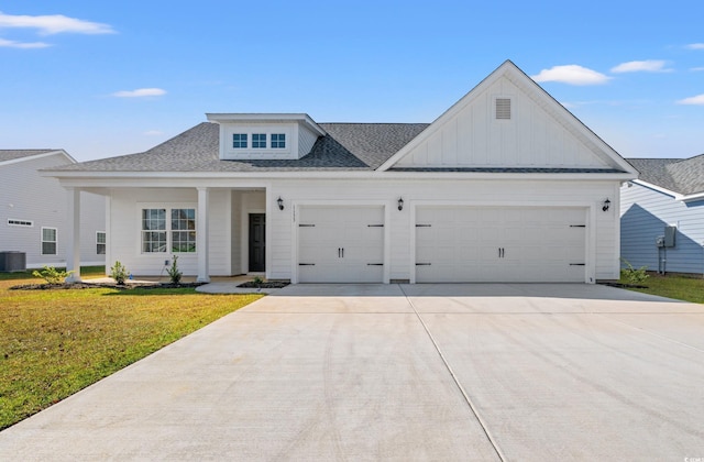 3324 Little Bay Dr, Conway, SC 29526 - view of front of house featuring an attached garage, board and batten siding, a front lawn, driveway, and cooling unit