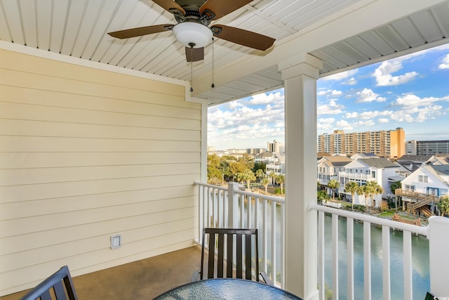 balcony featuring a water view and ceiling fan