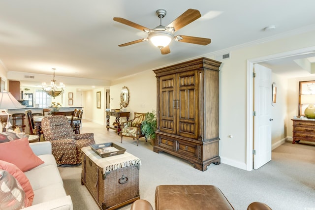 living area with light carpet, ceiling fan with notable chandelier, baseboards, visible vents, and ornamental molding