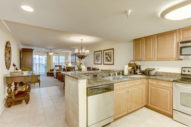 kitchen featuring a sink, appliances with stainless steel finishes, light brown cabinets, and a peninsula