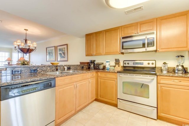 kitchen featuring stainless steel appliances, visible vents, a sink, and light brown cabinets