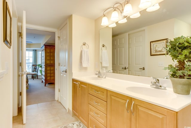 bathroom featuring double vanity, a sink, tile patterned floors, and a chandelier