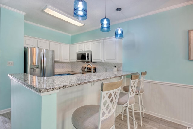 130 Scotch Broom Dr Unit H-103, Little River, SC 29566 - kitchen featuring tasteful backsplash, stainless steel appliances, white cabinets, and light wood-style flooring