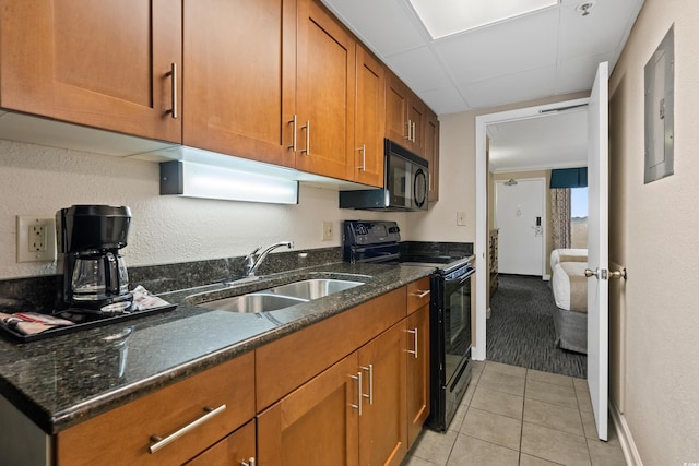 1200 N Ocean Blvd Unit 710, Myrtle Beach, SC 29577 - kitchen with a sink, brown cabinetry, dark stone countertops, light tile patterned floors, and black appliances