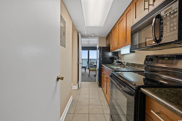 1200 N Ocean Blvd Unit 710, Myrtle Beach, SC 29577 - kitchen featuring a sink, brown cabinetry, baseboards, light tile patterned floors, and black appliances