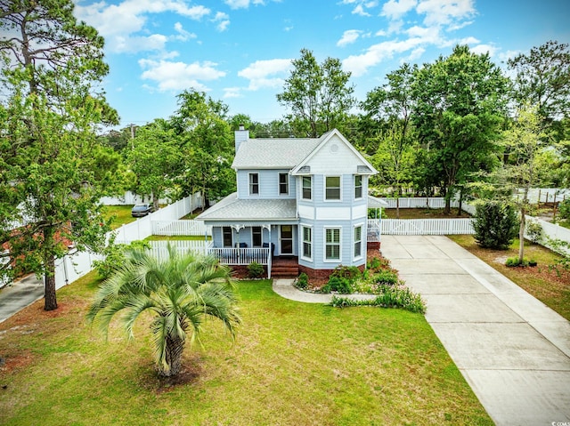 221 Lander Dr, Conway, SC 29526 - victorian-style house with covered porch, a chimney, concrete driveway, roof with shingles, and view of wooded area
