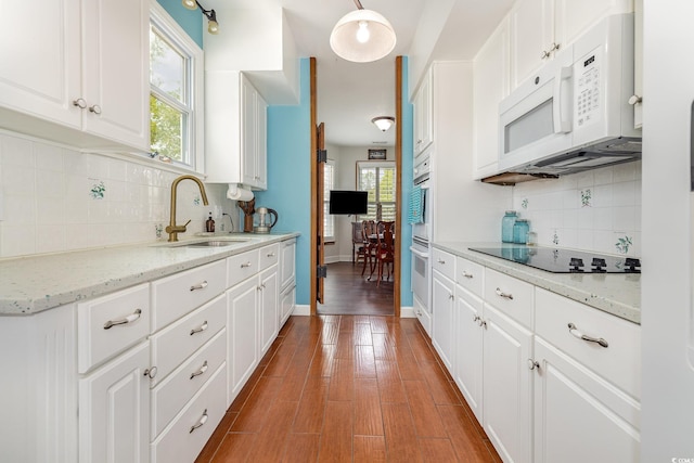 221 Lander Dr, Conway, SC 29526 - kitchen with a sink, white microwave, black electric stovetop, and backsplash