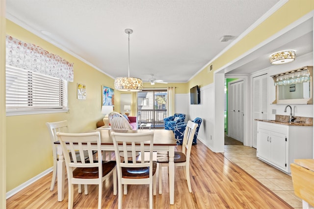 dining space with crown molding, light wood-style flooring, ceiling fan, and visible vents