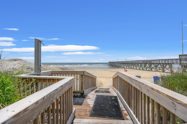 view of property's community featuring a beach view, a fire pit, and a water view