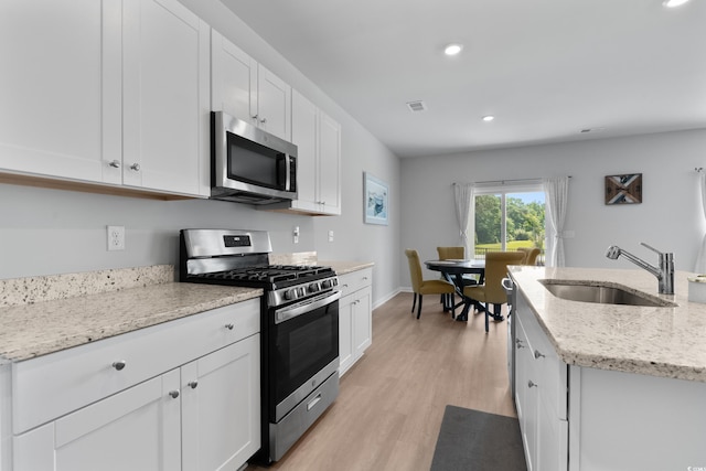 109 River Vista Way, Myrtle Beach, SC 29588 - kitchen featuring appliances with stainless steel finishes, a sink, white cabinets, recessed lighting, and light wood-style floors