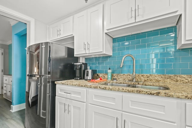 7200 Ocean Blvd N Unit 664, Myrtle Beach, SC 29572 - kitchen with a sink, freestanding refrigerator, wood finished floors, white cabinets, and decorative backsplash