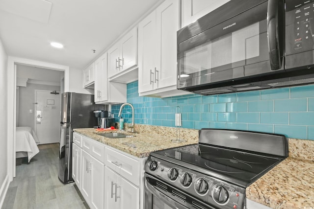 7200 Ocean Blvd N Unit 664, Myrtle Beach, SC 29572 - kitchen with stainless steel appliances, white cabinets, a sink, light wood-type flooring, and decorative backsplash