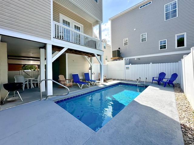 view of pool with a patio area, a fenced backyard, and central AC unit