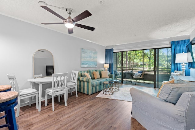 living area featuring crown molding, a textured ceiling, ceiling fan, and wood finished floors