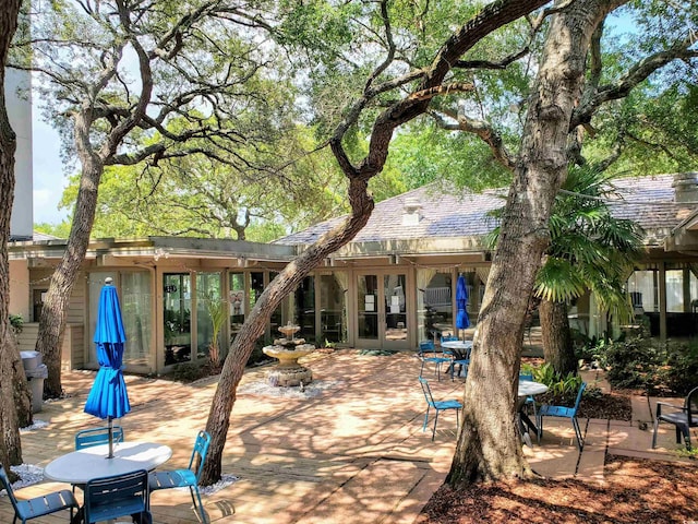 rear view of property with a patio, french doors, and outdoor dining space