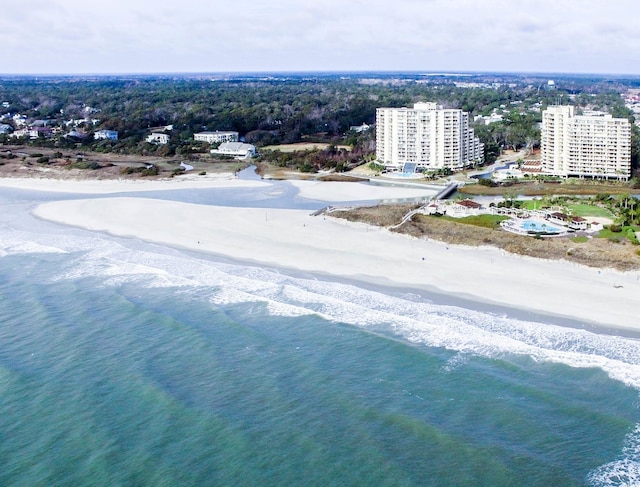 birds eye view of property featuring a water view and a beach view