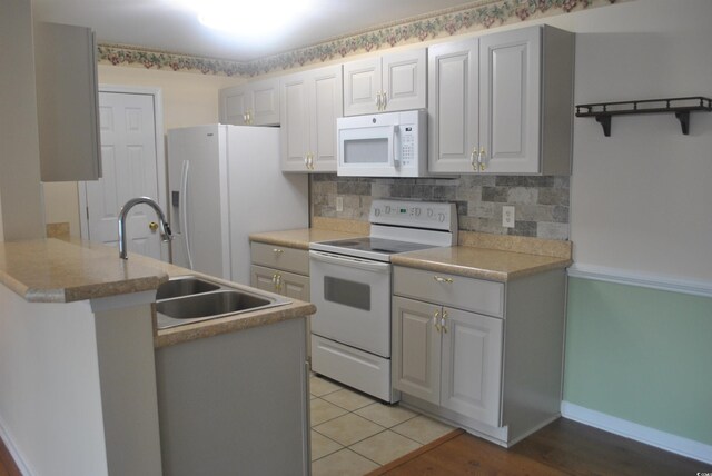 22 Woodhaven Dr Unit C, Murrells Inlet, SC 29576 - kitchen with white appliances, tasteful backsplash, a peninsula, a sink, and baseboards